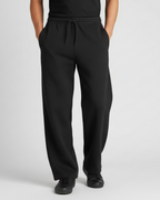Euphor Bliss unisex black loose-fit sweatpants with an elastic drawstring waist and side pockets on a model